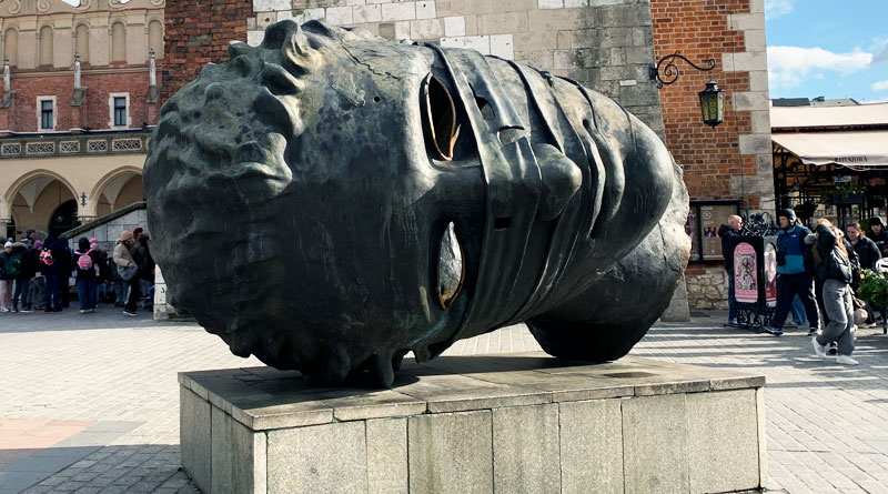 Бронзовая голова на рыночной площади в Кракове